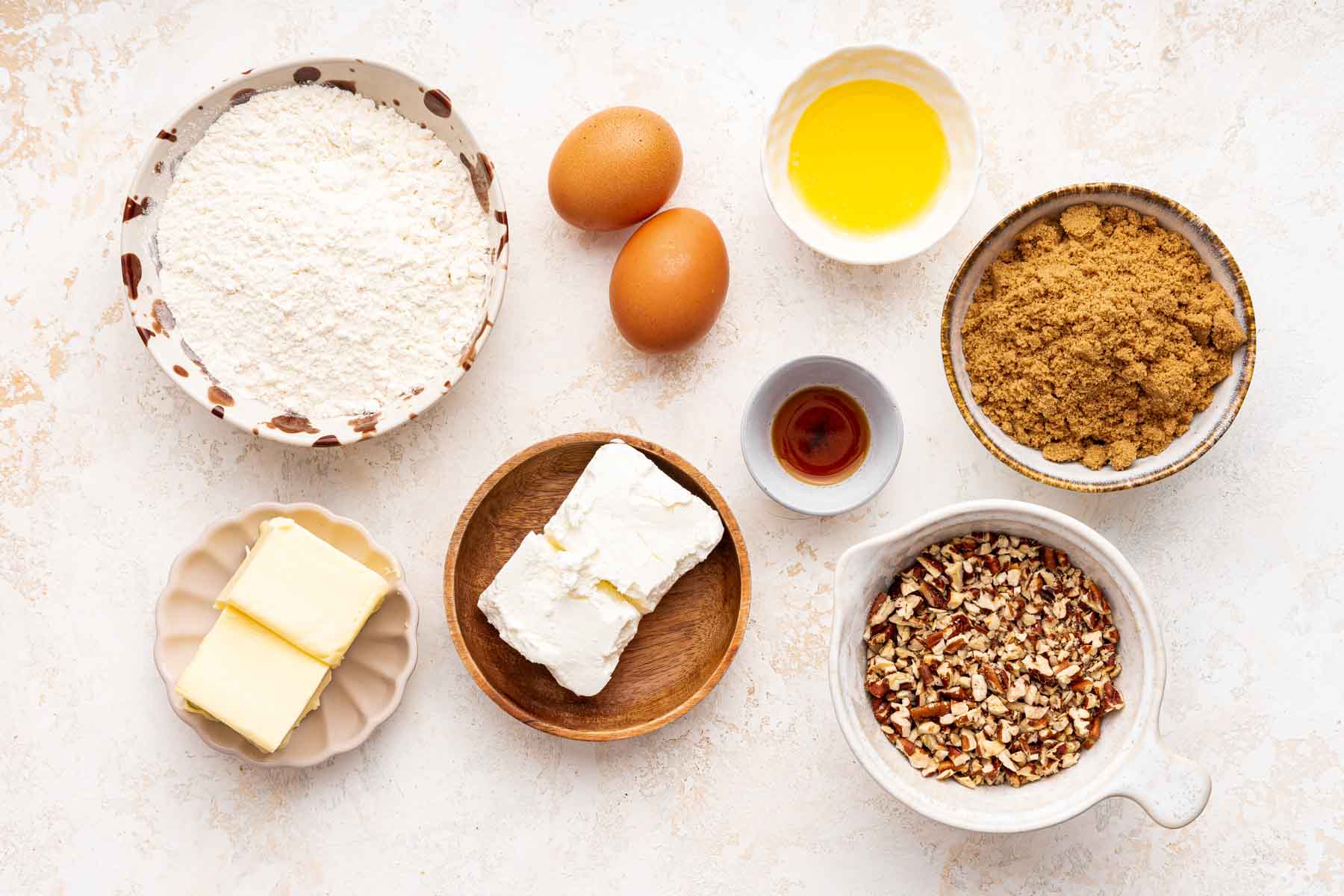 Small bowls with flour, brown sugar, nuts, butter and cream cheese.
