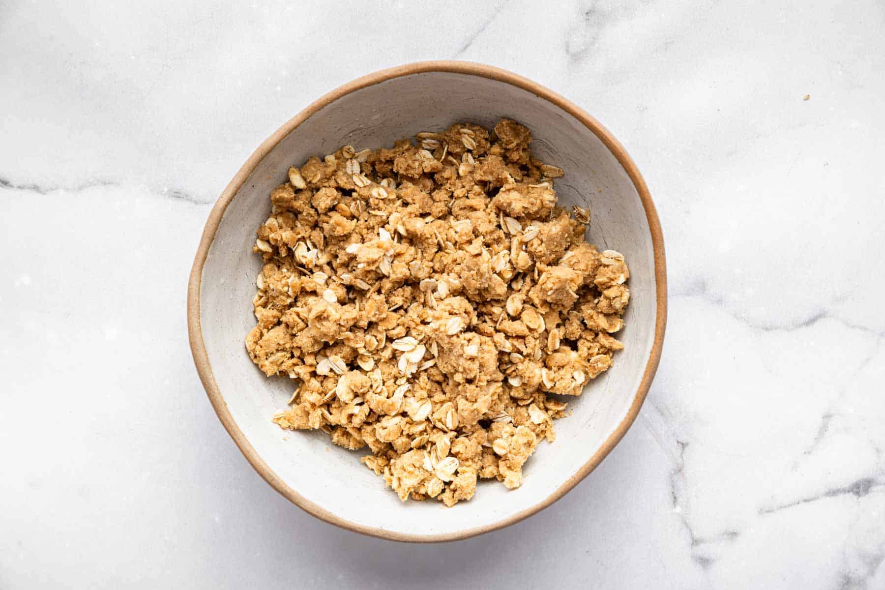 Crumbly bowl of oats with brown sugar and butter.
