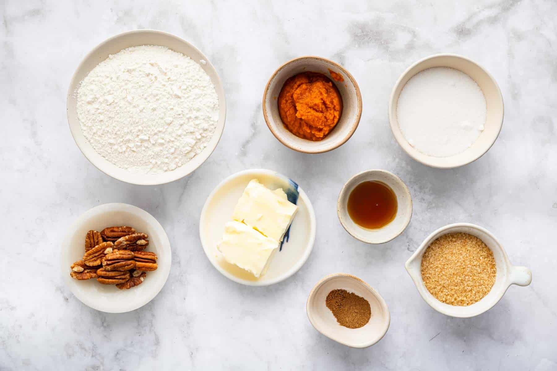 Small bowls of spices, softened butter, pecans, and sugar.