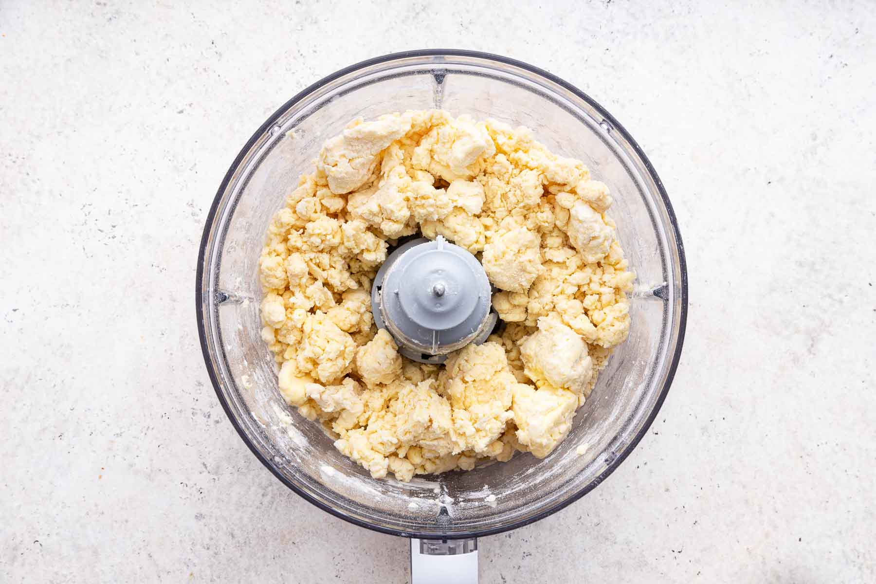 Cream cheese pastry crust in a food processor, overhead shot.