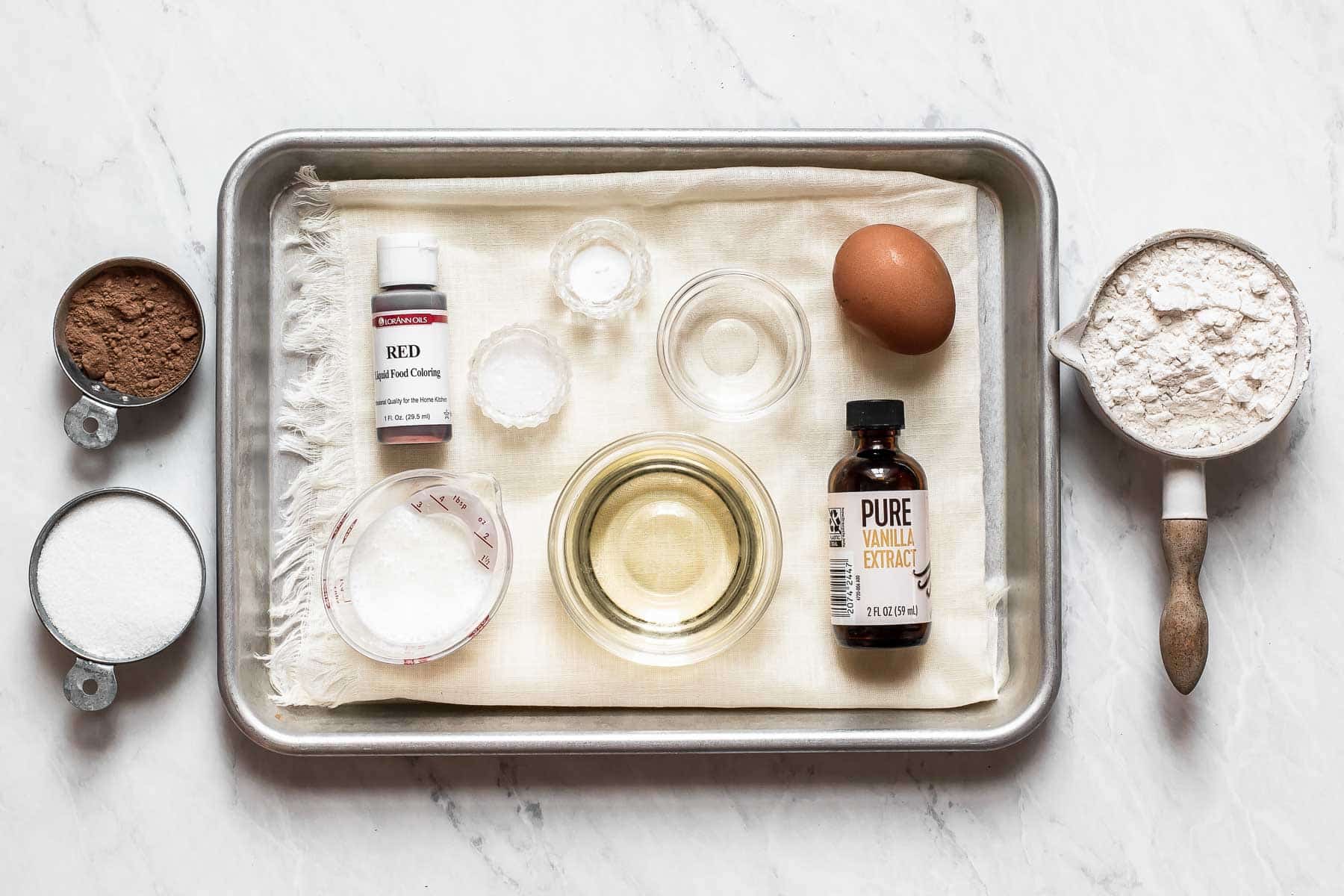 Ingredients to make red velvet truffles on baking sheet.