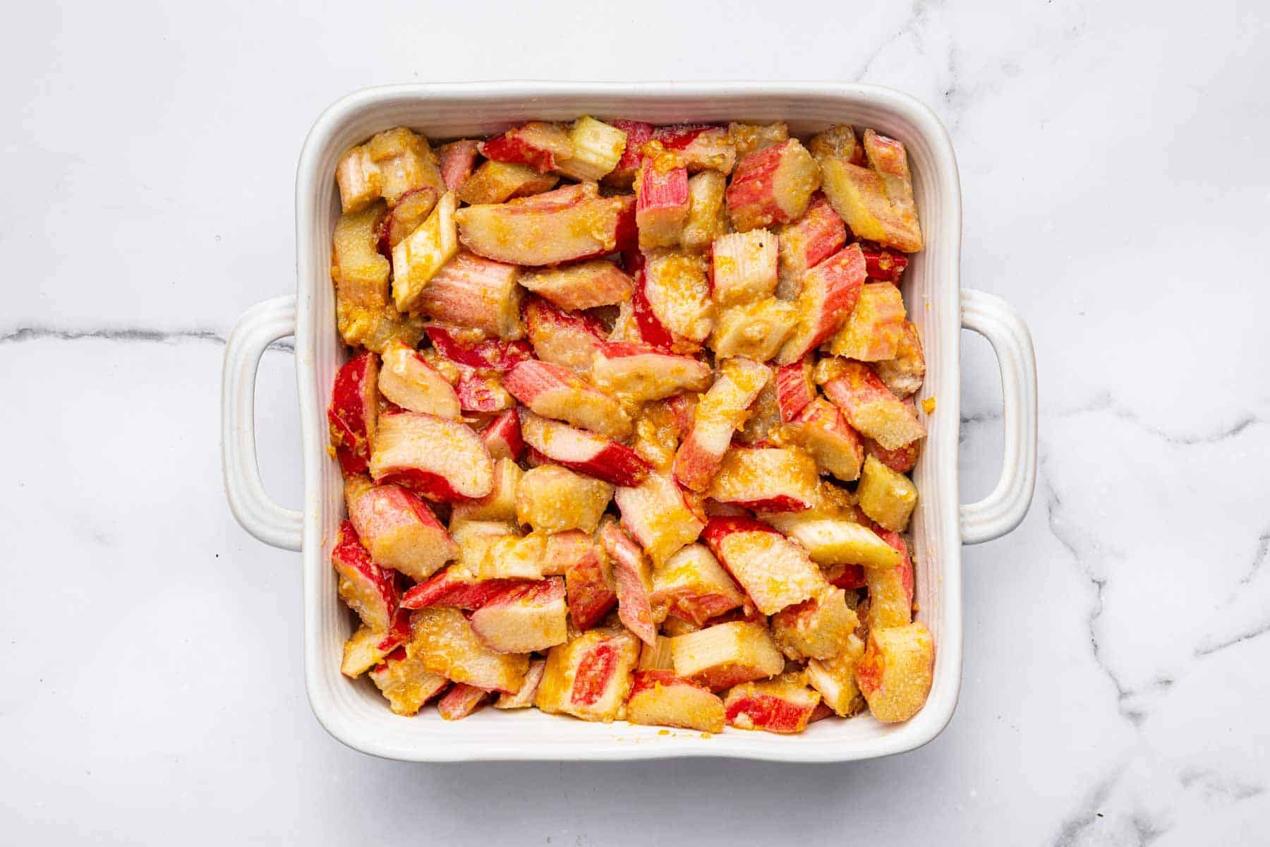 Marinated fruit in a square baking dish, waiting for topping.