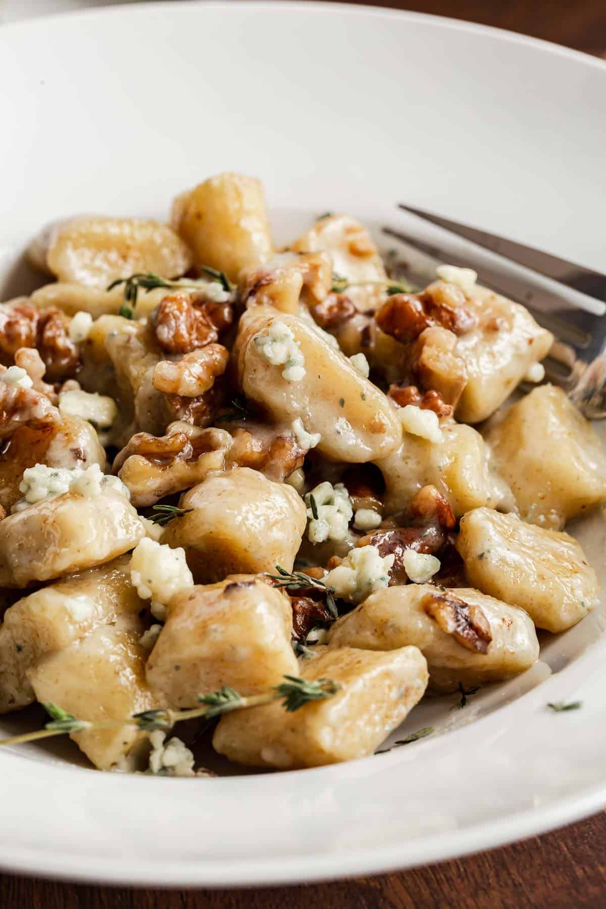 Close up of ricotta gnocchi in serving bowl.