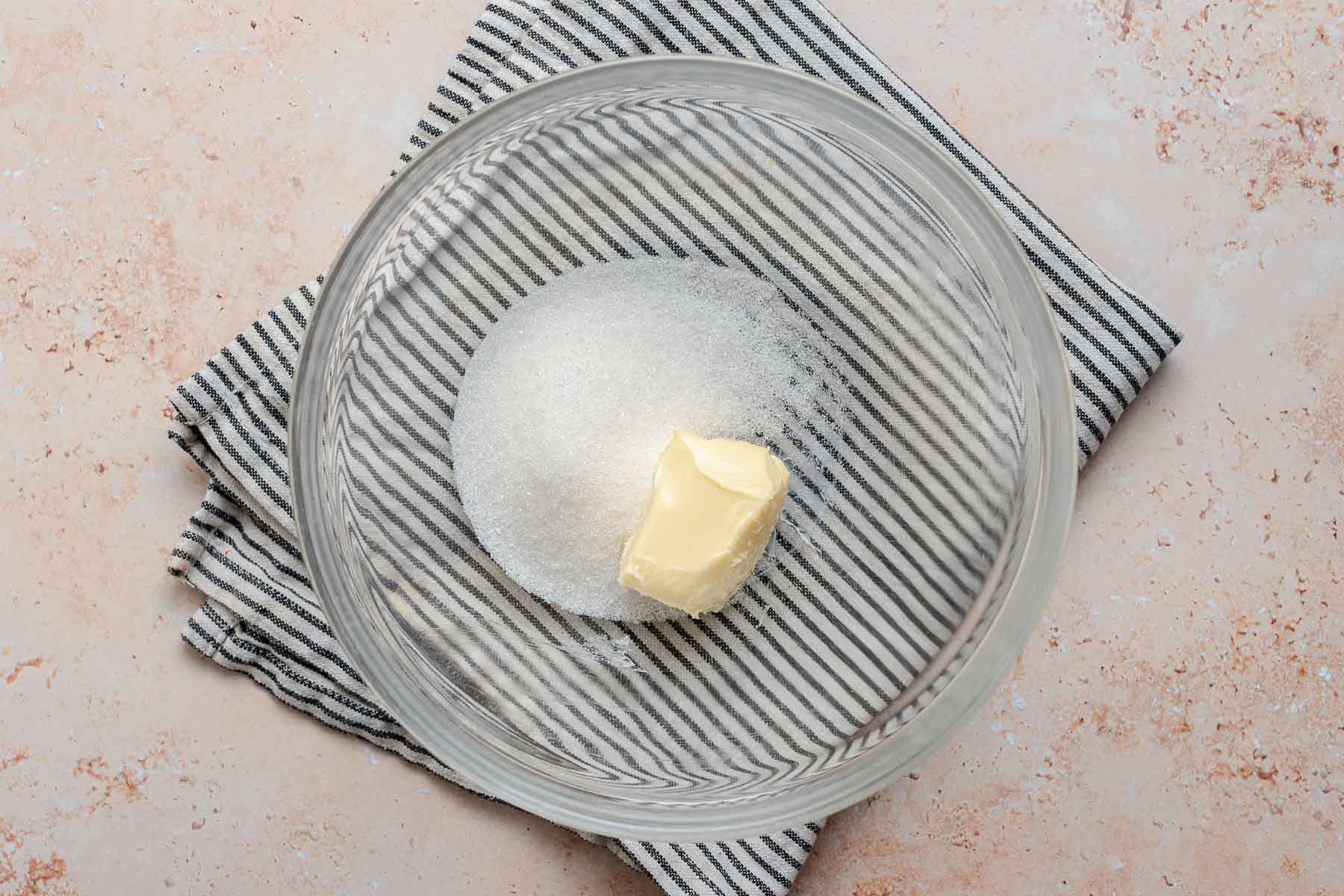 Butter and granulated sugar in clear glass bowl.