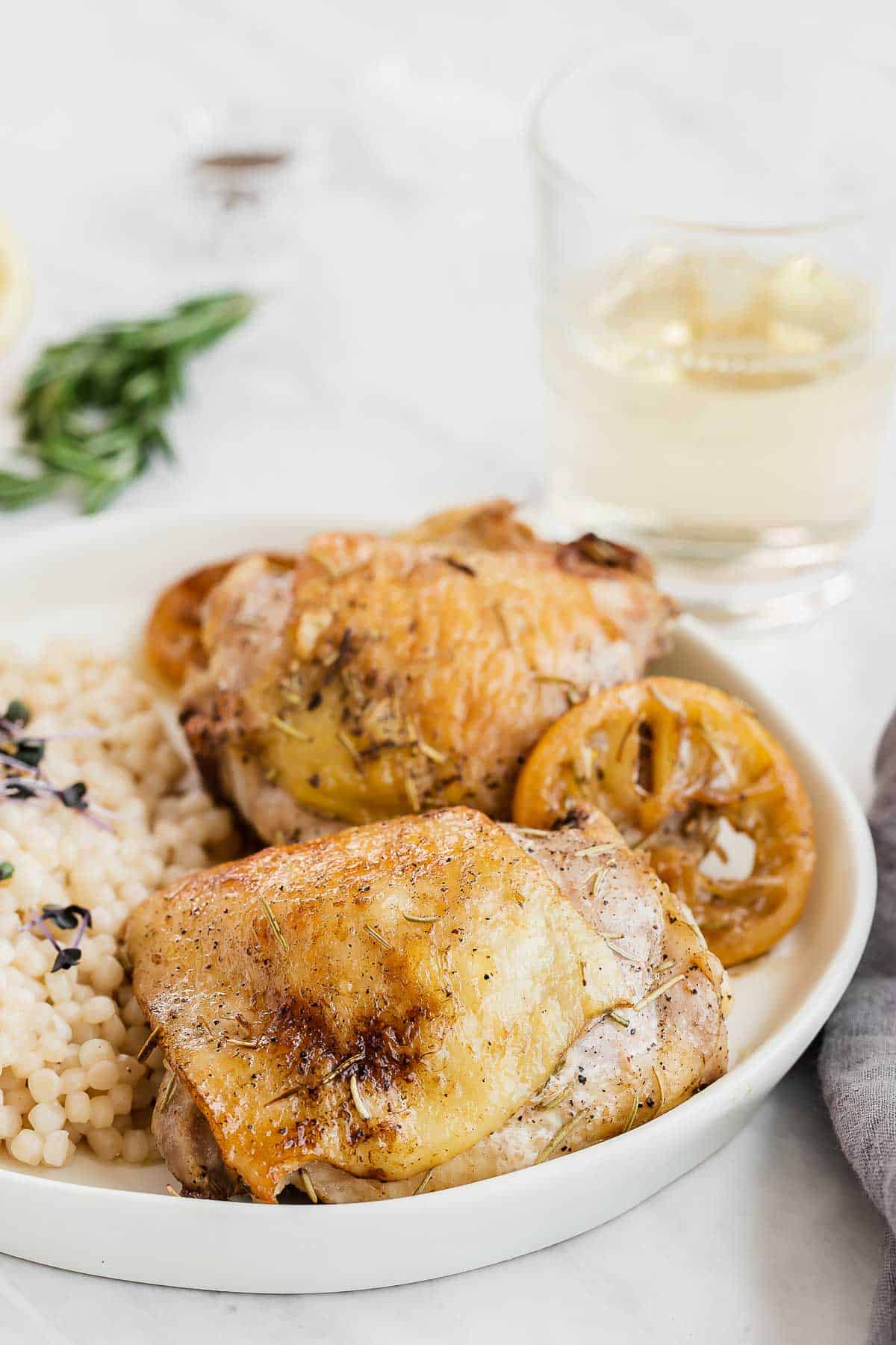 two chicken thighs roasted in the oven on a plate