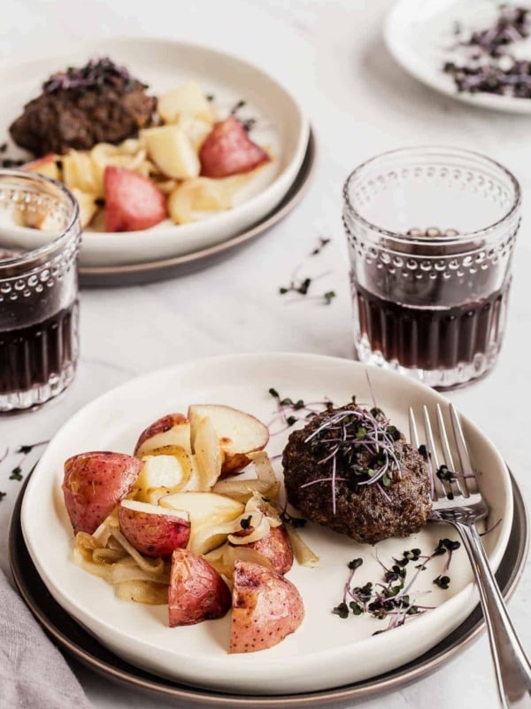 two plates with potatoes and small salisbury steak