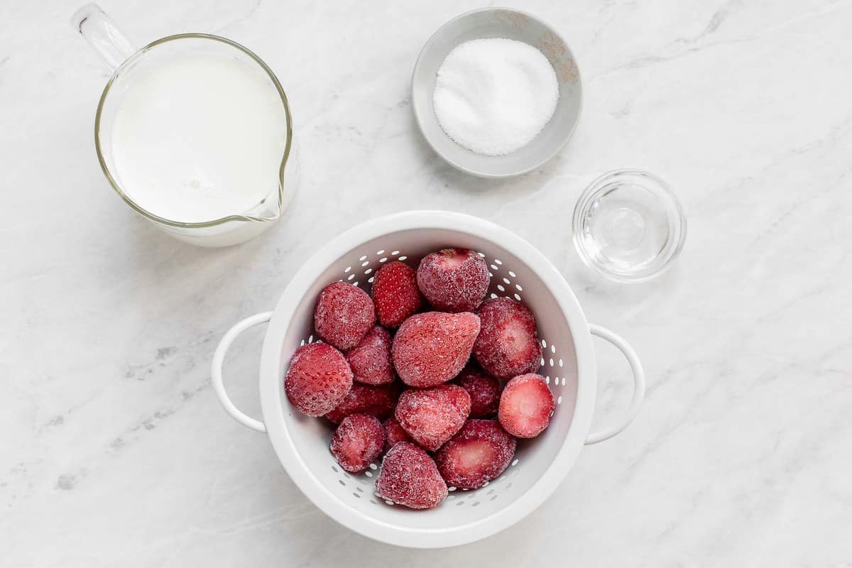 Ingredients for strawberry milk on table.