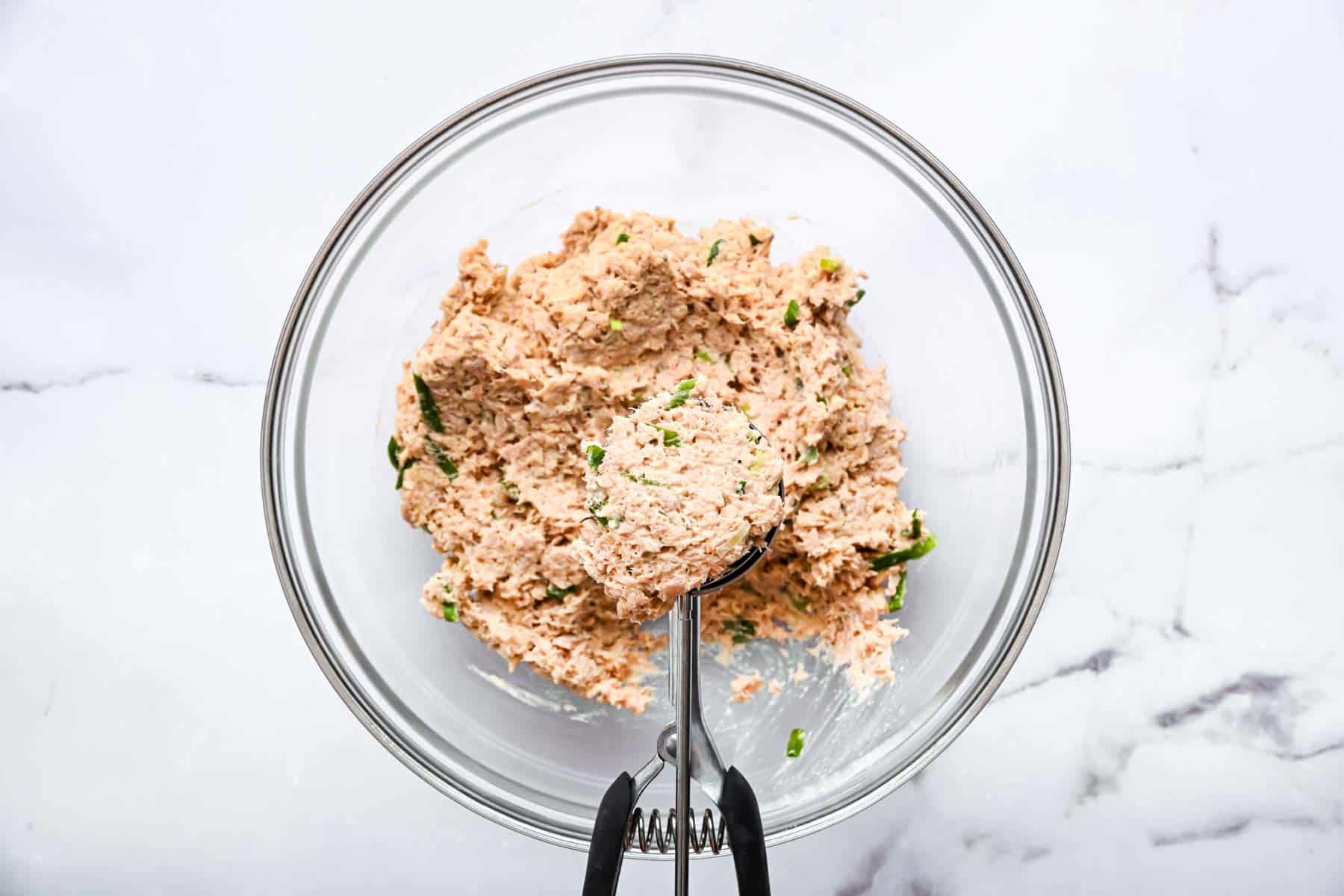 Ice cream scoop portioning out fritter batter.