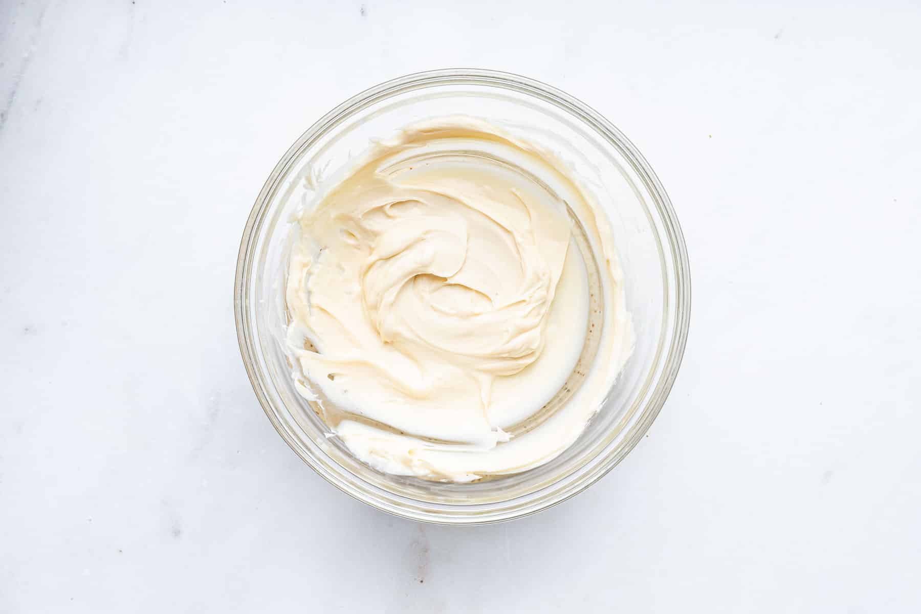 Clear bowl of melted white chocolate.